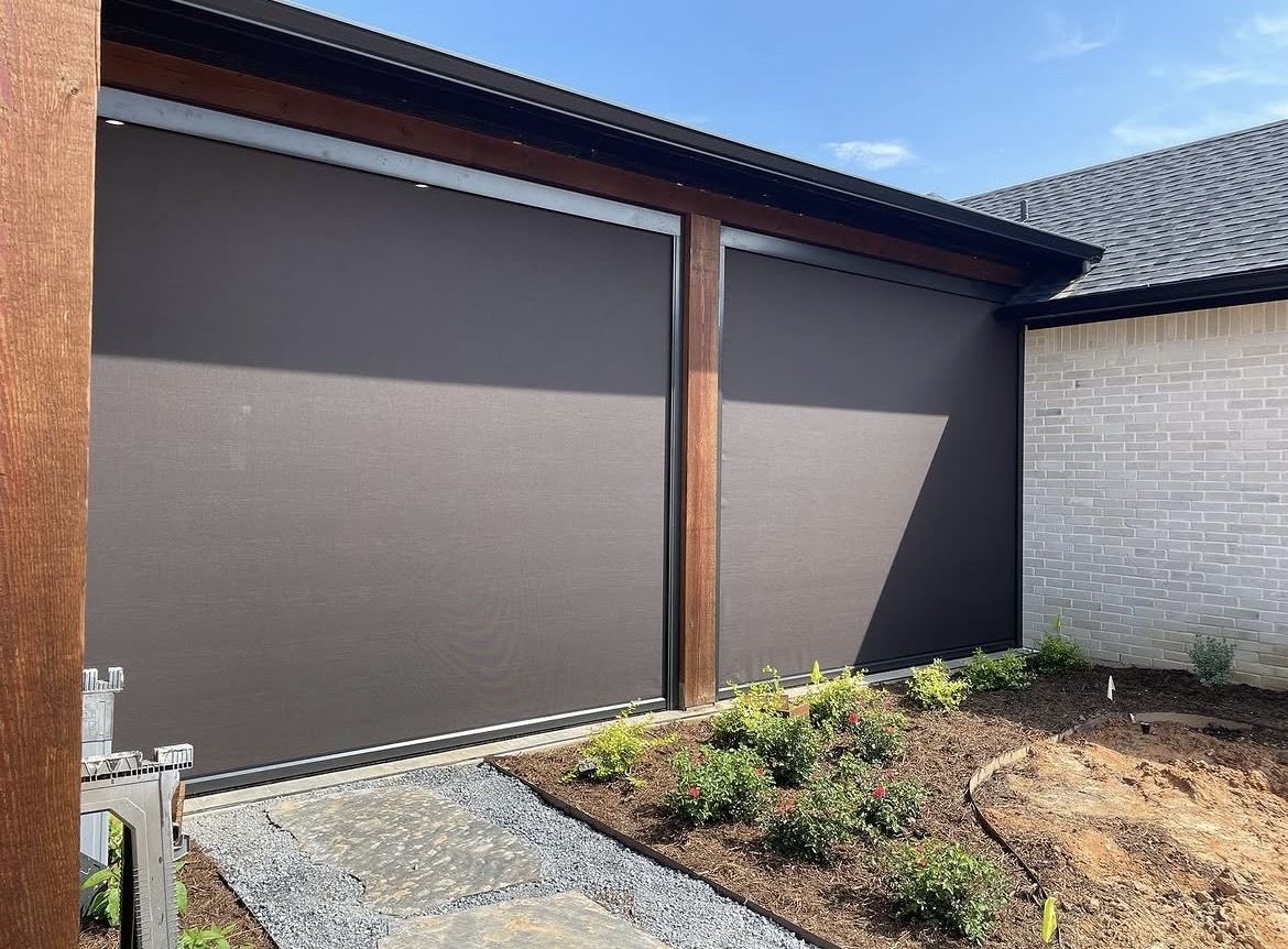 Corner patio enclosed with motorized screens and landscaping