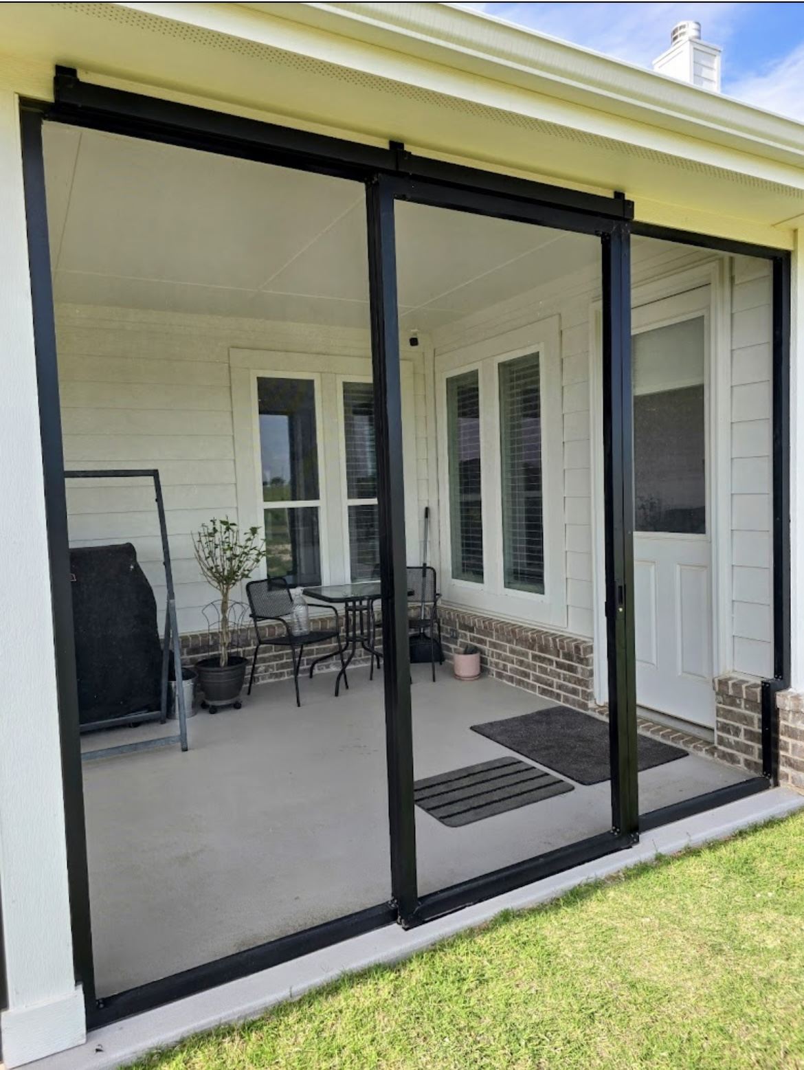 Screen room with sliding glass doors and patio furniture