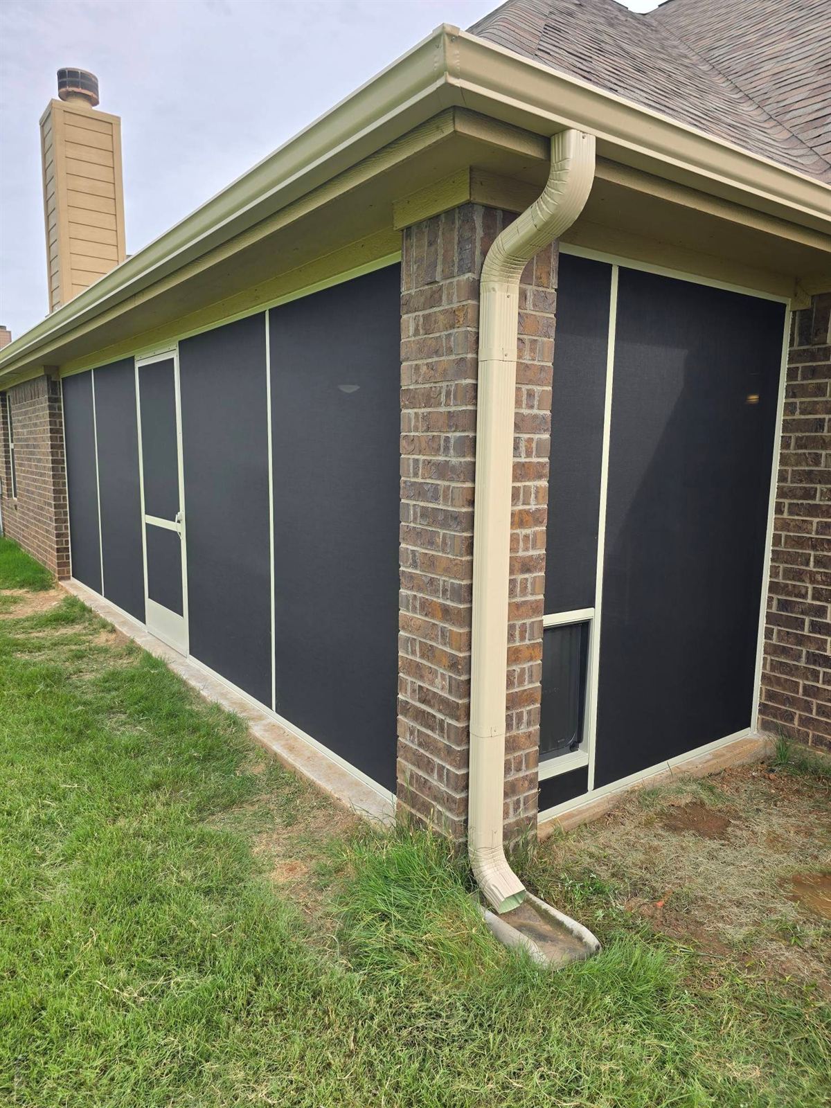 Enclosed screen room on a brick DFW home with a green lawn