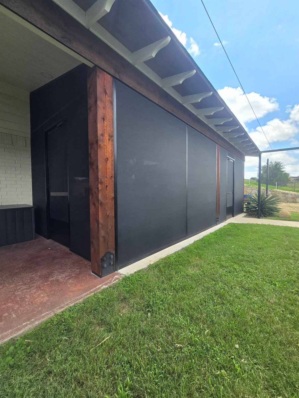 Screen room with a dark wood accent wall on a DFW patio