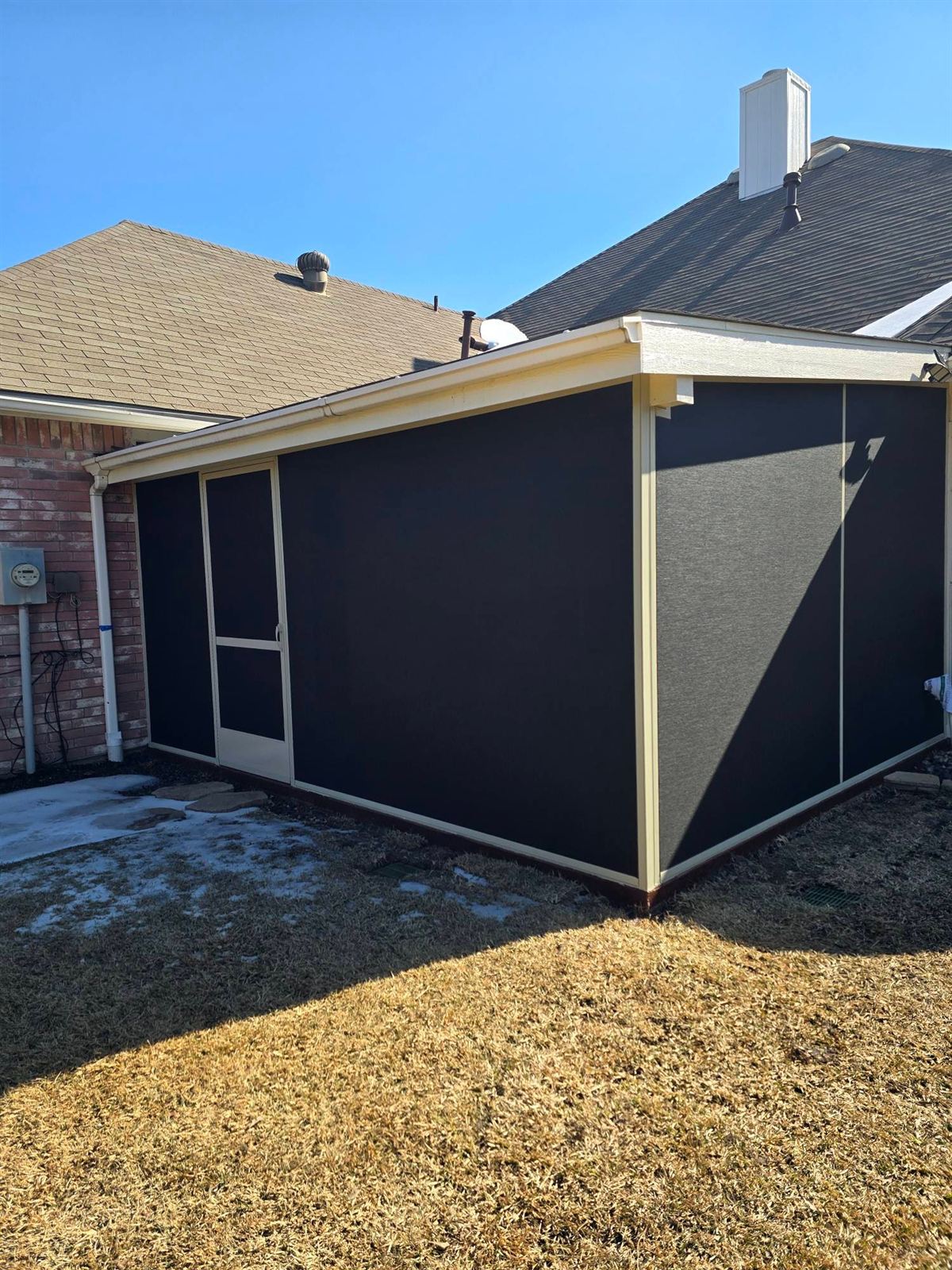 Black-framed screen room on the corner of a DFW backyard