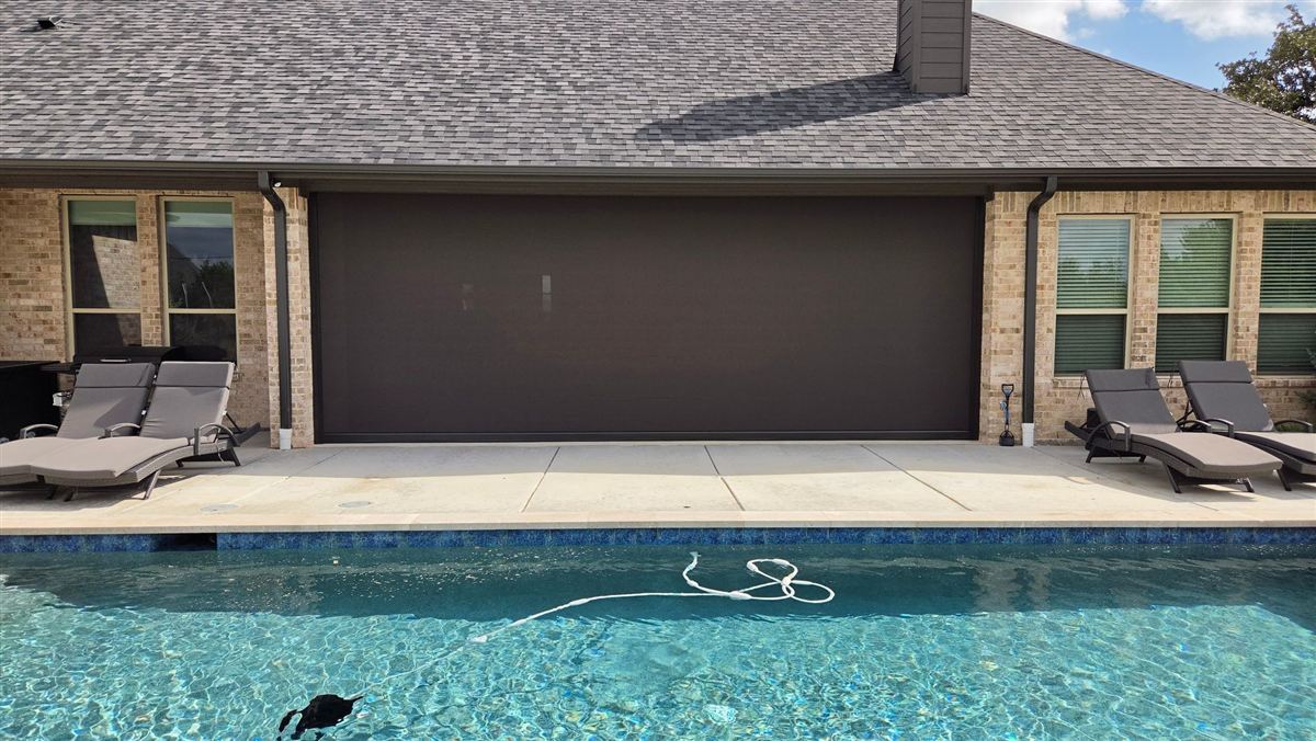 Nano 95 Tobacco motorized screen installed over a patio, viewed from outside by the pool