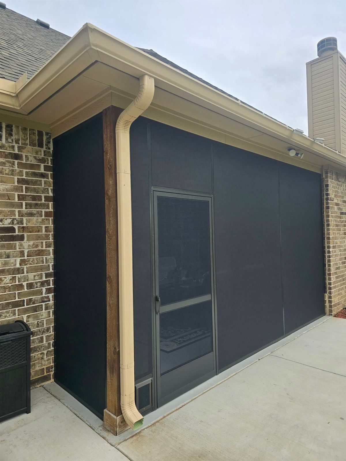 Enclosed screen room with a screen-door entry on a brick DFW home